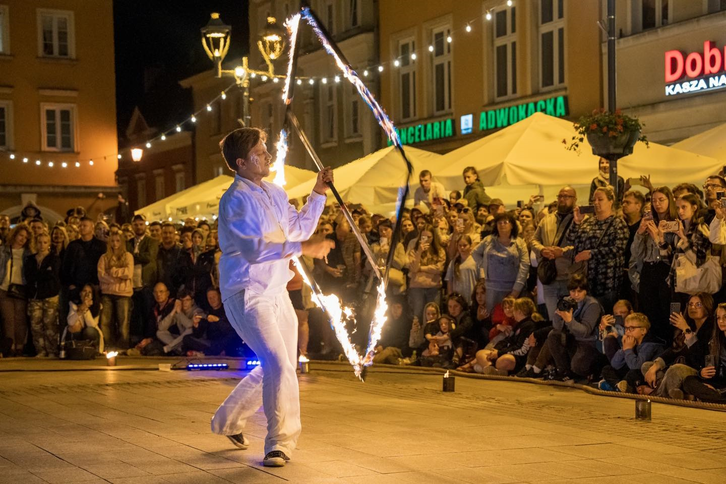 Fot. G.Ożga/UM Gliwice artysta ze świecącą konstrukcją, wokół ludzie, Rynek.