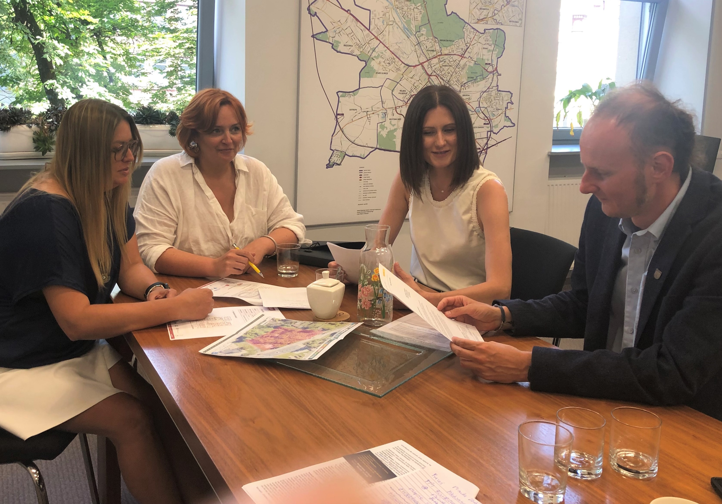 O toczących się przygotowaniach do budowy szkoły przedstawicielki Fundacji Sawanci rozmawiały ostatnio z Łukaszem Gorczyńskim, zastępcą prezydenta Gliwic Zdjęcie trzech pań z fundacji z wiceprezydentem Gliwic przy stole