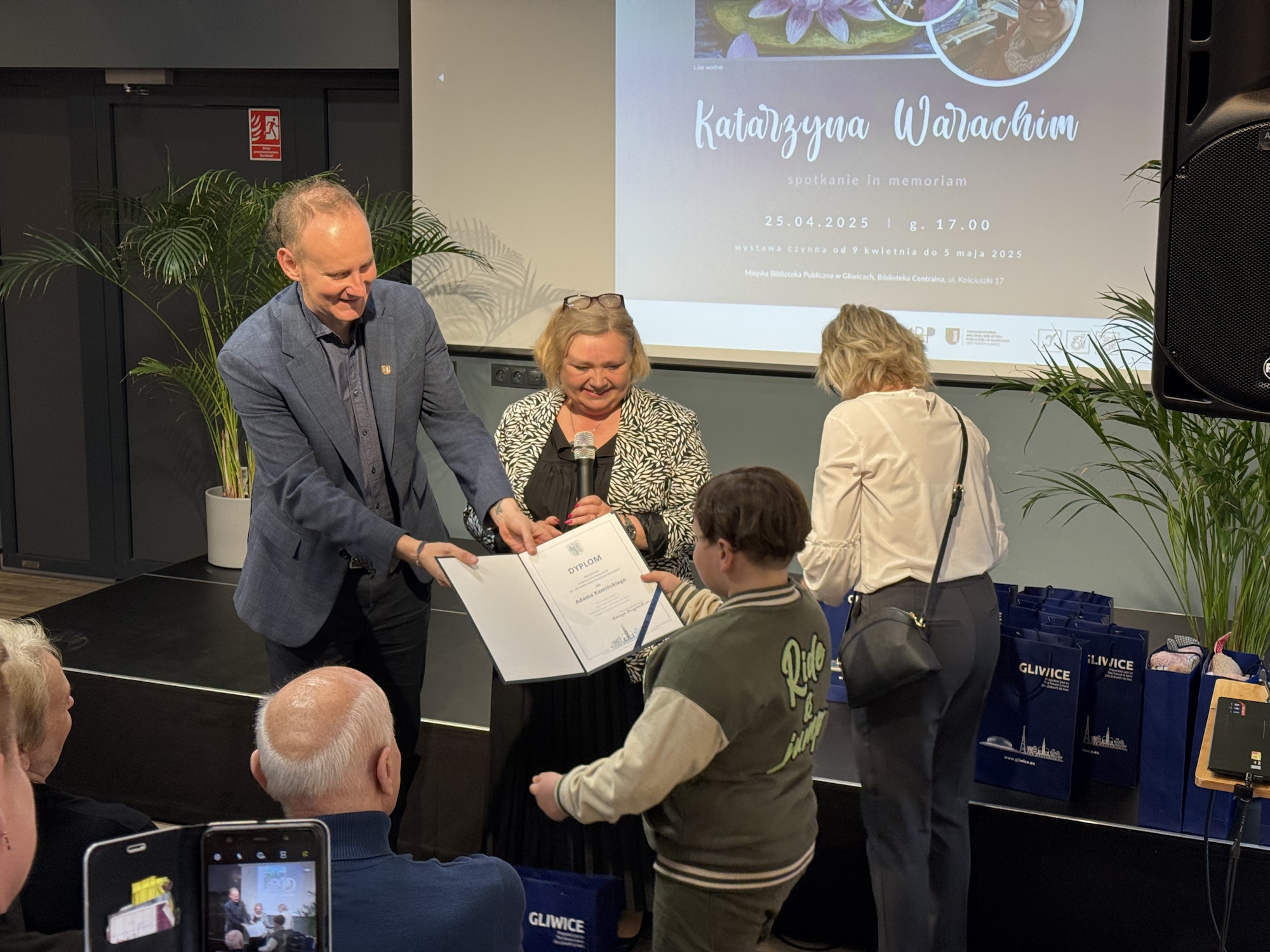 Fot. UM w Gliwicach Łukasz Gorczyński i Klaudia Bera wręczają chłopcu wyróżnienie