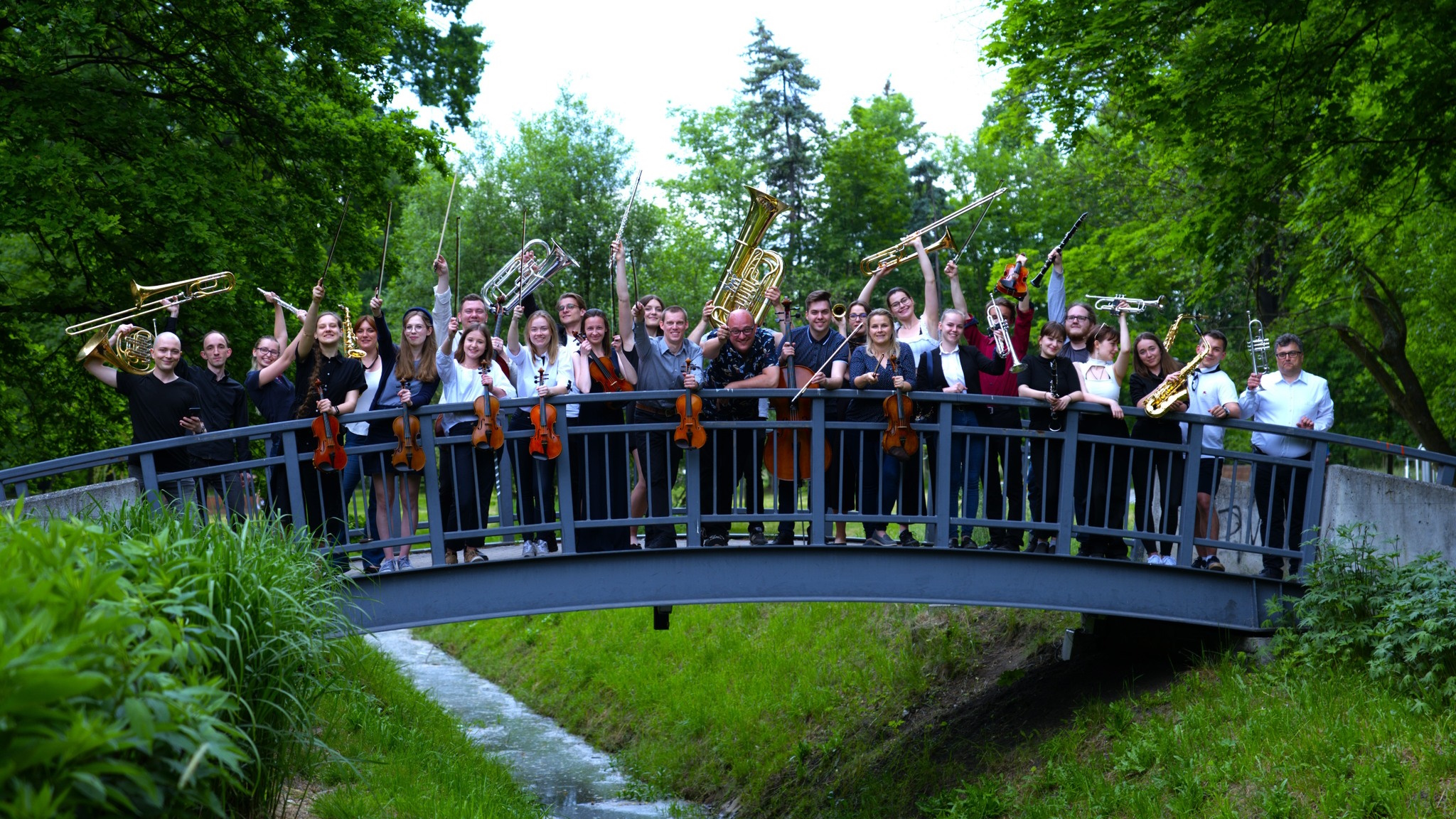 Orkiestra z instrumentami na moście nad rzeką