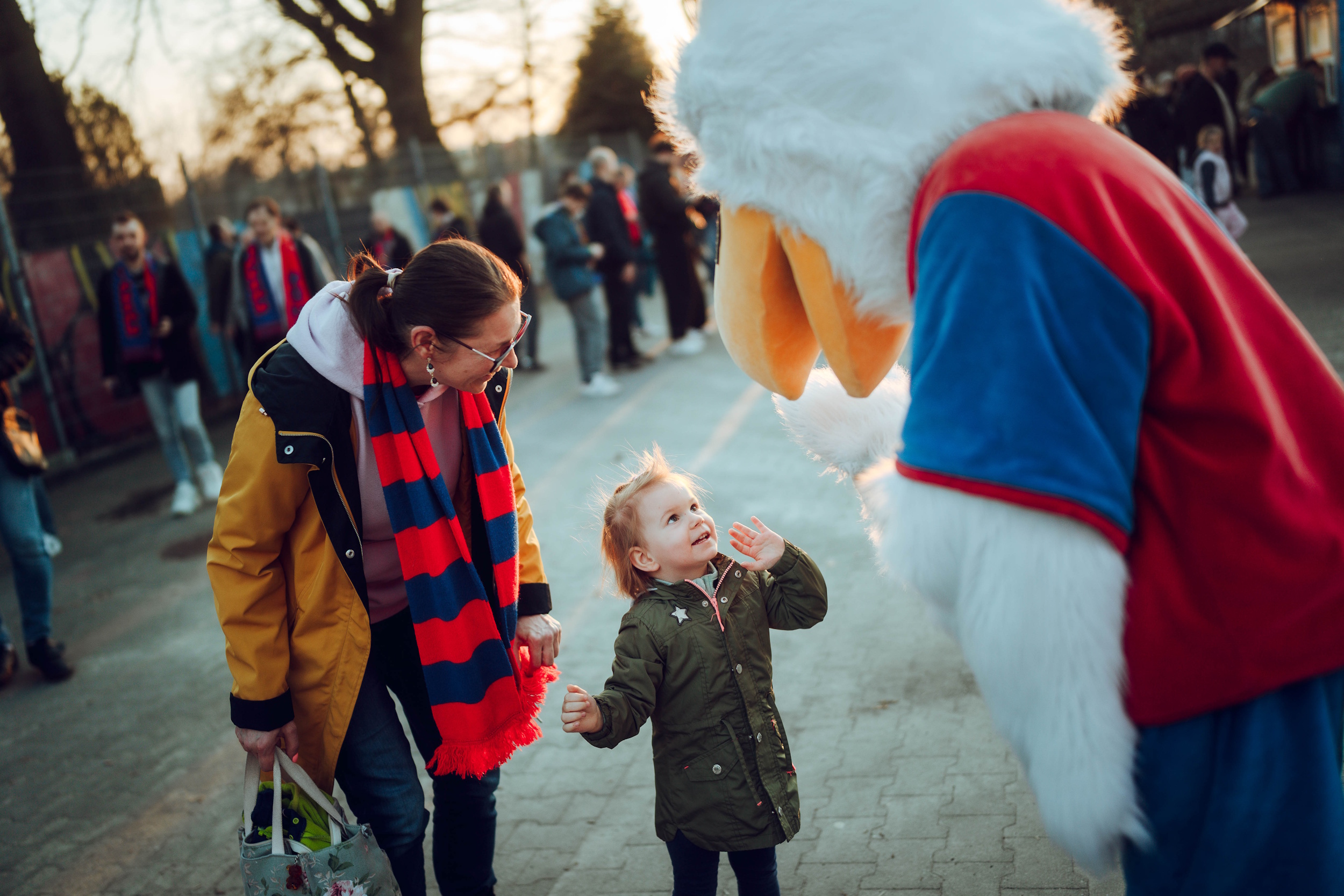Mała kibicka witająca się z maskotką Piasta