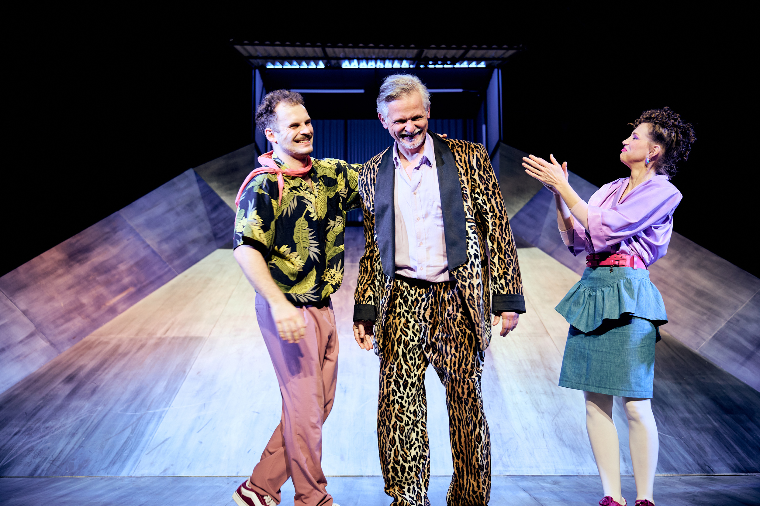 aktorzy na scenie Teatru w Gliwicach podczas spektaktlu "Ludzie bezdomni". Trzech aktorów - kobieta i dwóch mężczyzn na scenie, wszyscy w kolorowych ubraniach