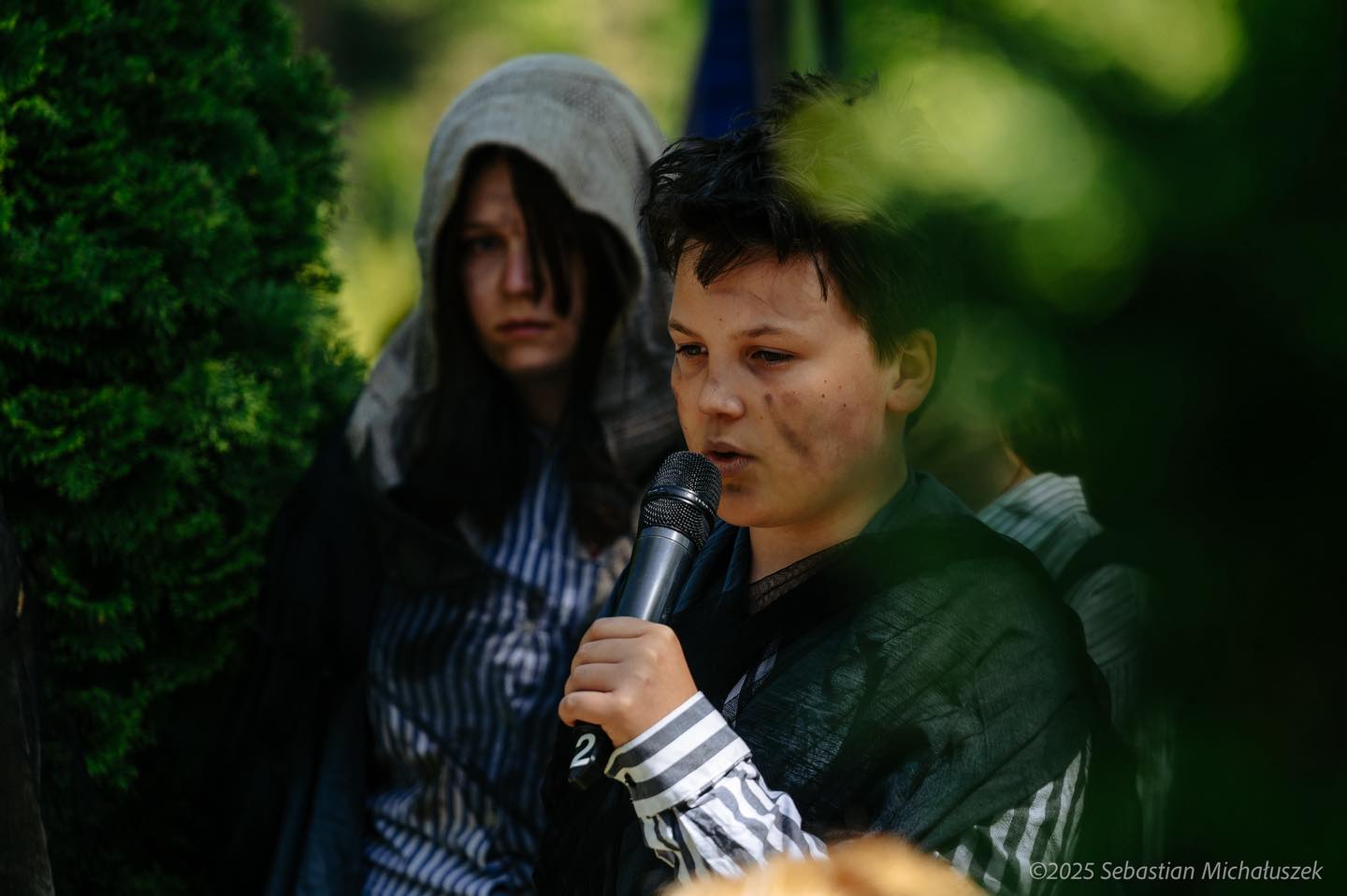 Fot. S.Michałuszek/UM Gliwice młody człowiek z mikrofonem z opaską na nadgarstku