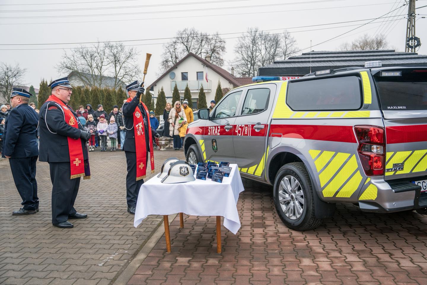 ludzie z kropidłem i nowy samochód
