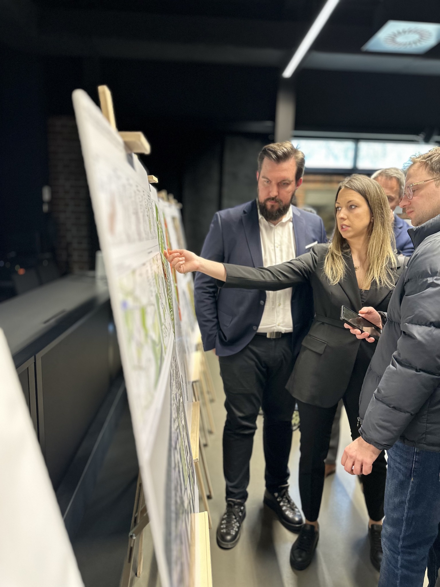 ludzie przy planszy z wizualizacją