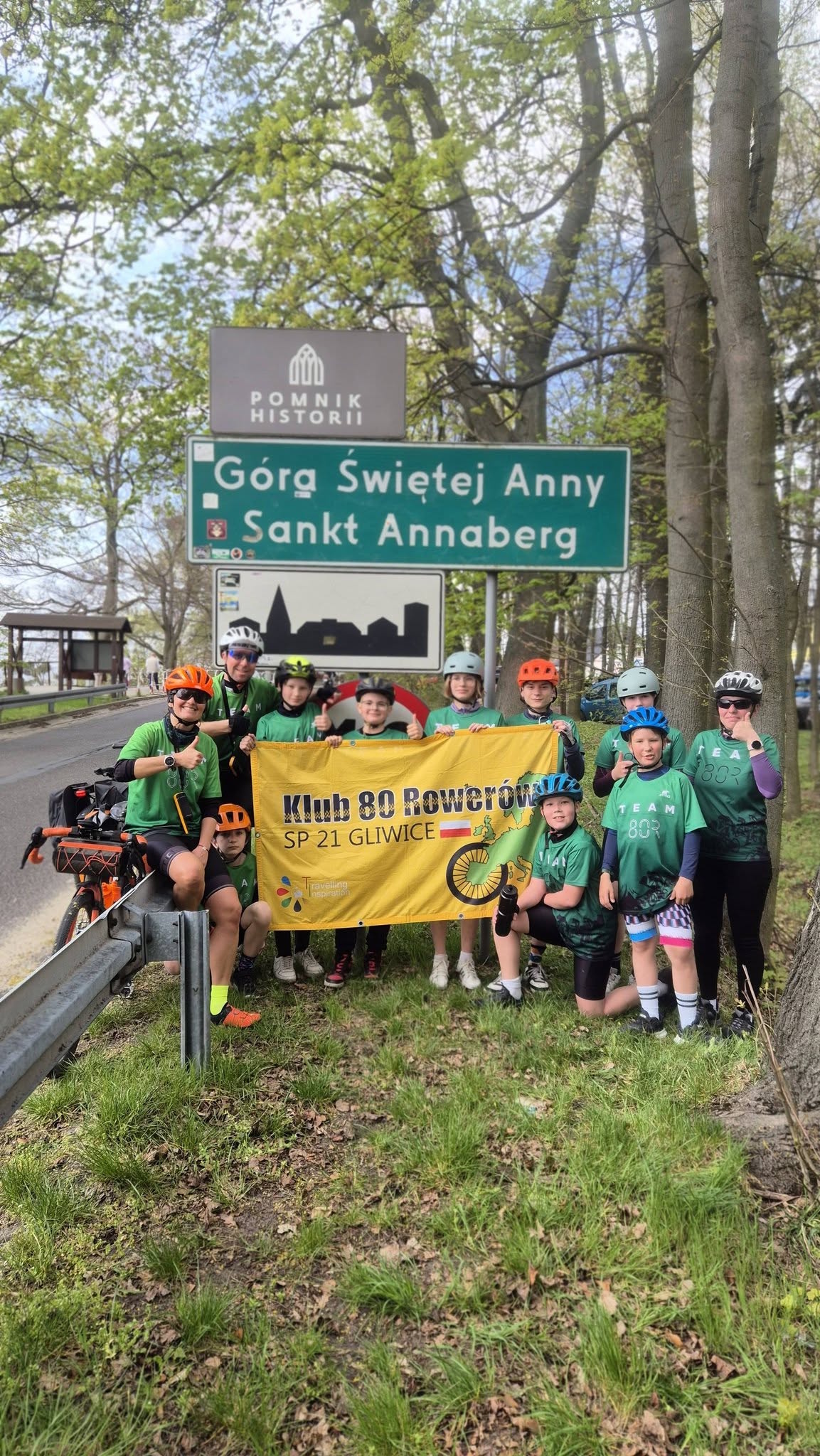 rowerzyści przy znaku wjazdowym miejscowości Góra św. Anny