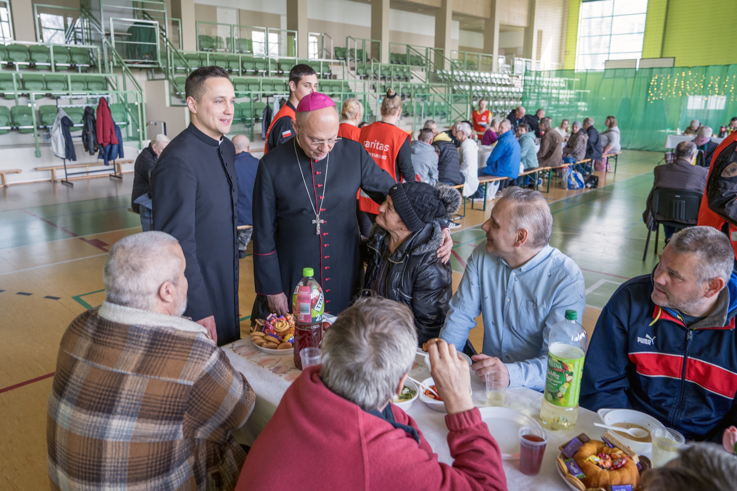 Biskup z jałmużnikiem rozmawiający z gośćmi