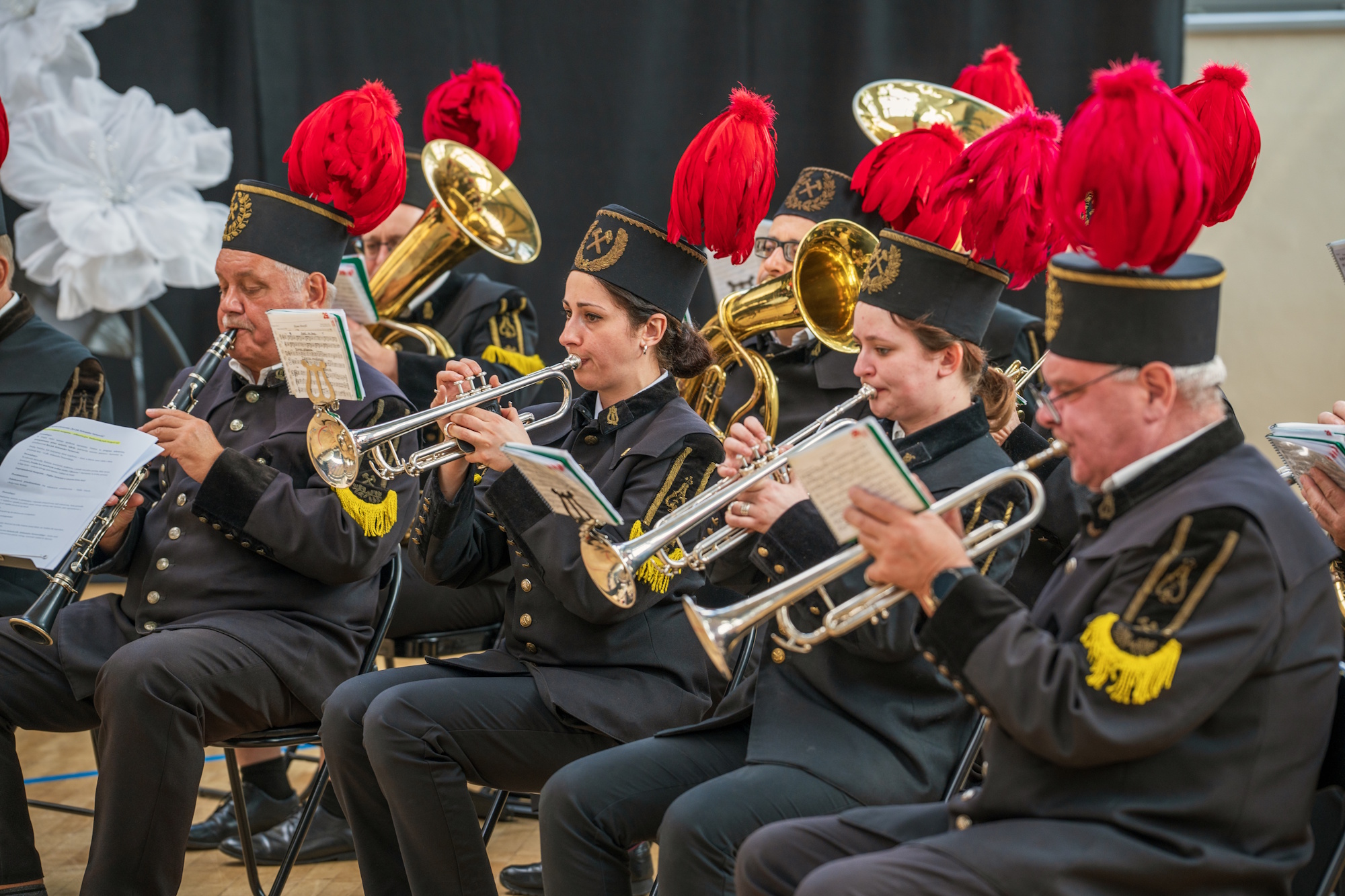 muzycy z orkiestry górniczej z czerwonymi pióropuszami