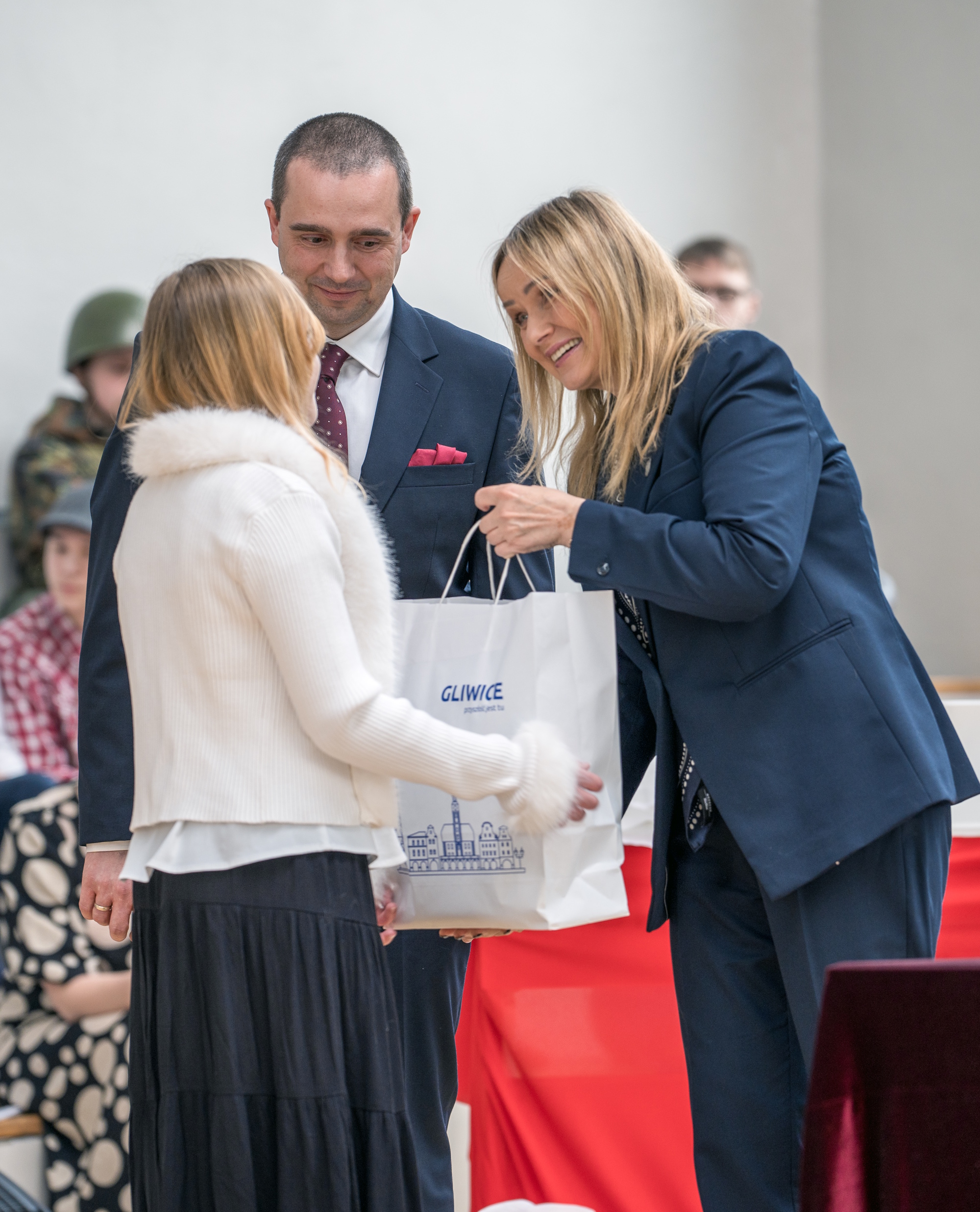 prezydent Gliwic wręcza prezent dziecku, obok stoi dyrektor szkoły
