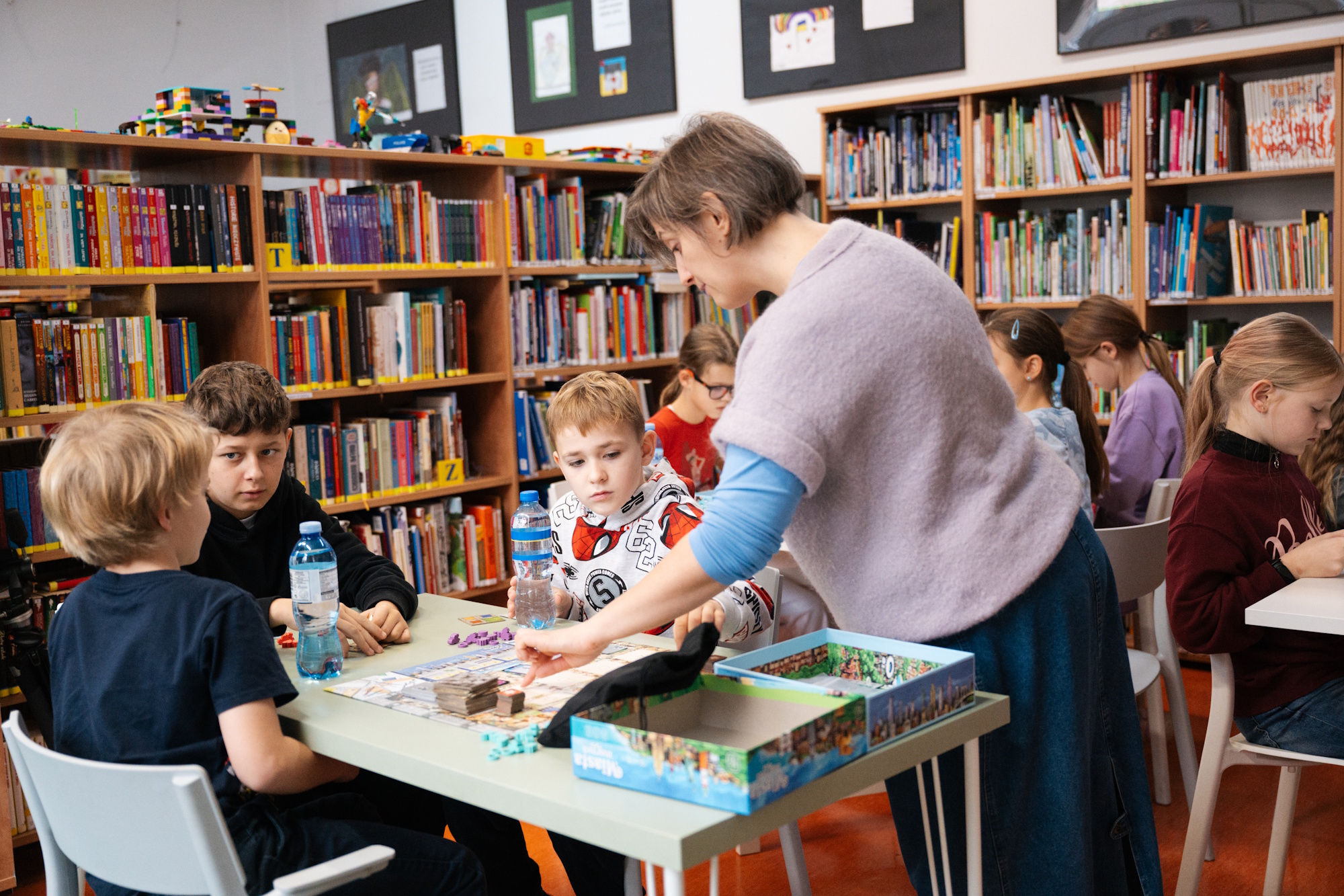 nauczyciel i dzieci w bibliotece
