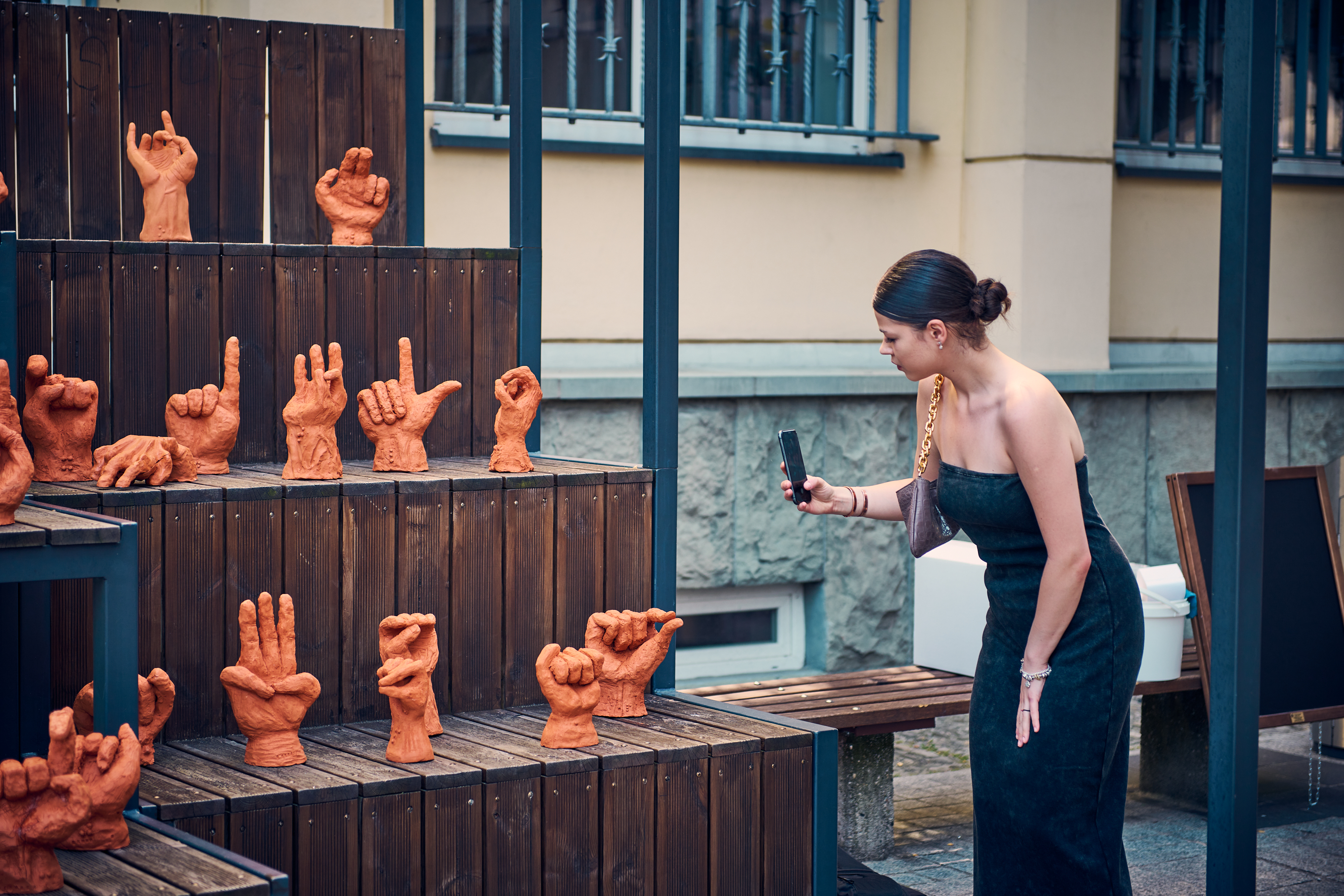 Dziewczyna fotografująca gliniane rzeźby dłoni