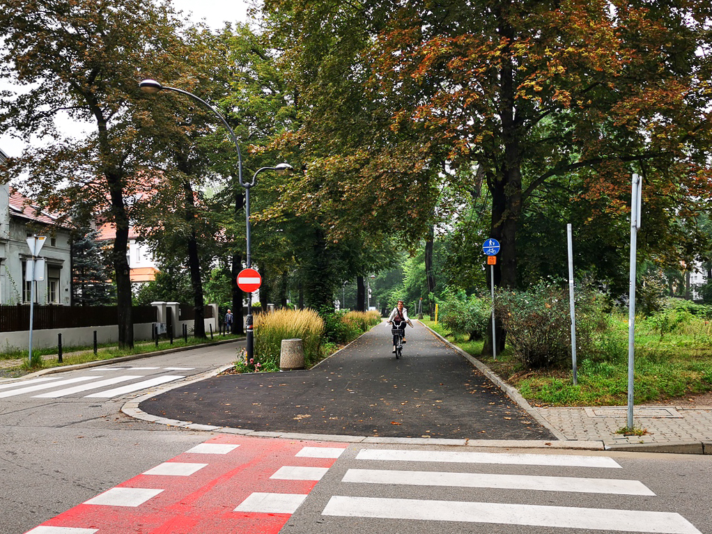 na zdjęciu rowerzystka przejeżdżająca ul.Berbeckiego