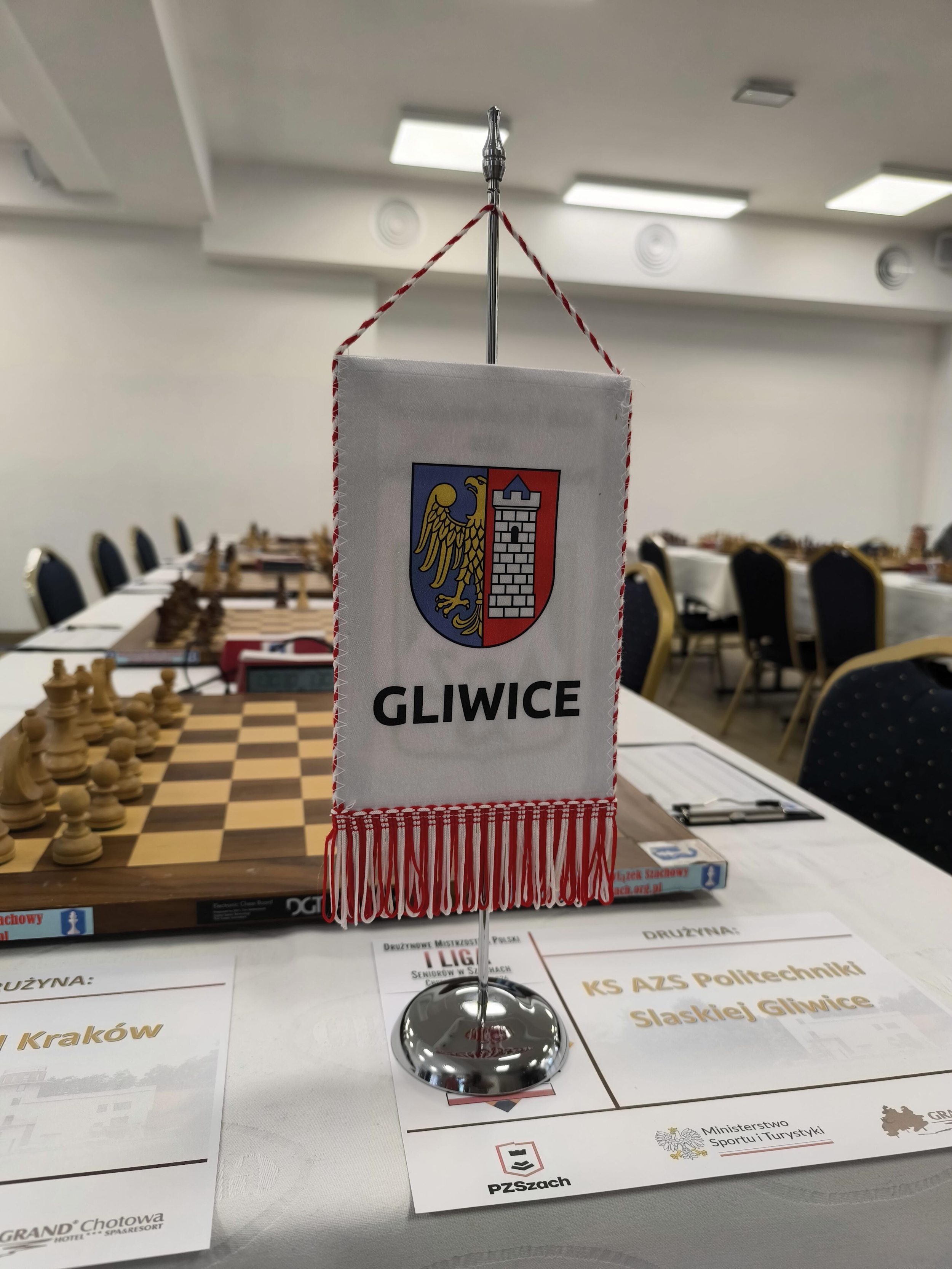 Proporczyk z herbem Gliwic na stole z szachownicami