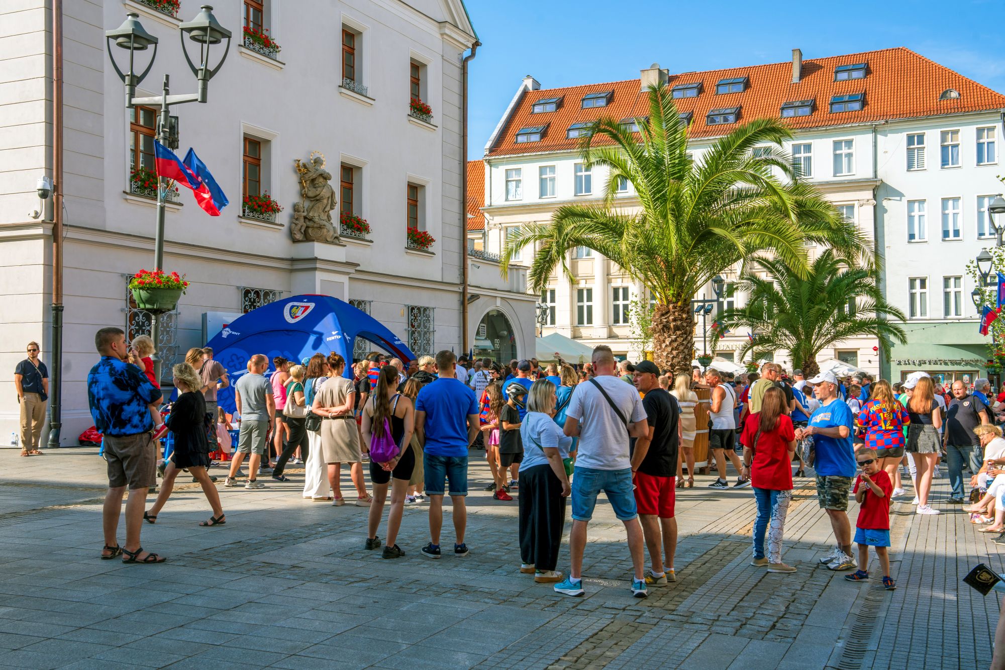 ludzie na Rynku wśród palm