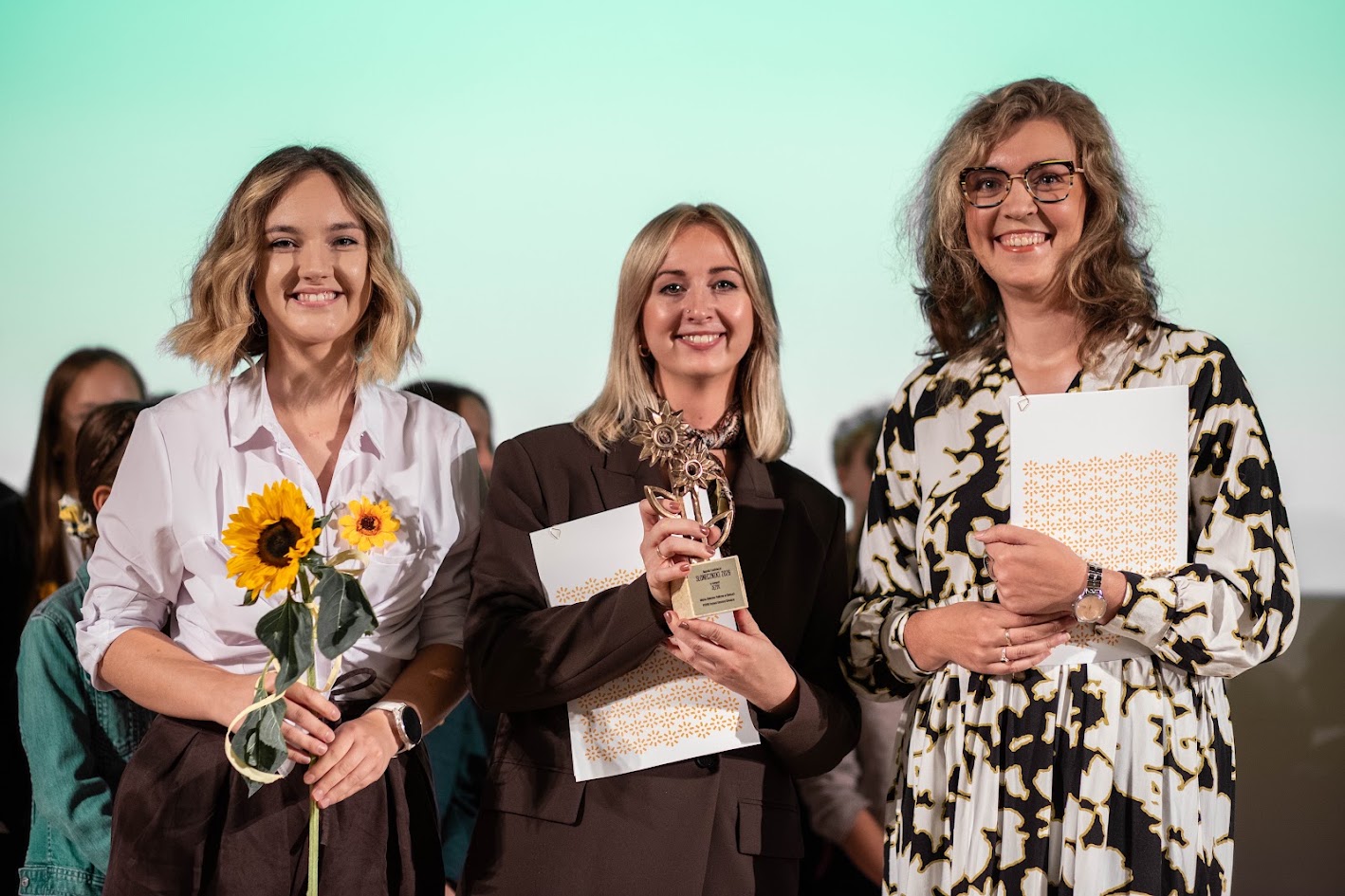Trzy kobiety z kwiatami i statuetką