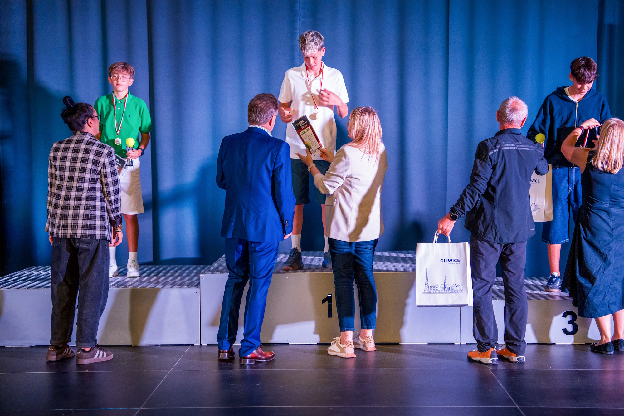 Wręczanie pucharów osobom, tóre stoją na podium