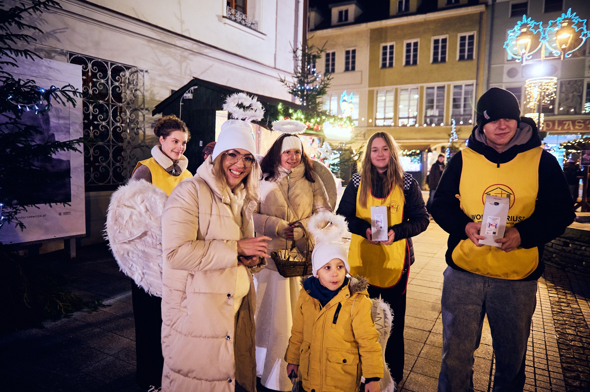 ludzie na rynku, jeden w żółtej kamizelce Hospicjum