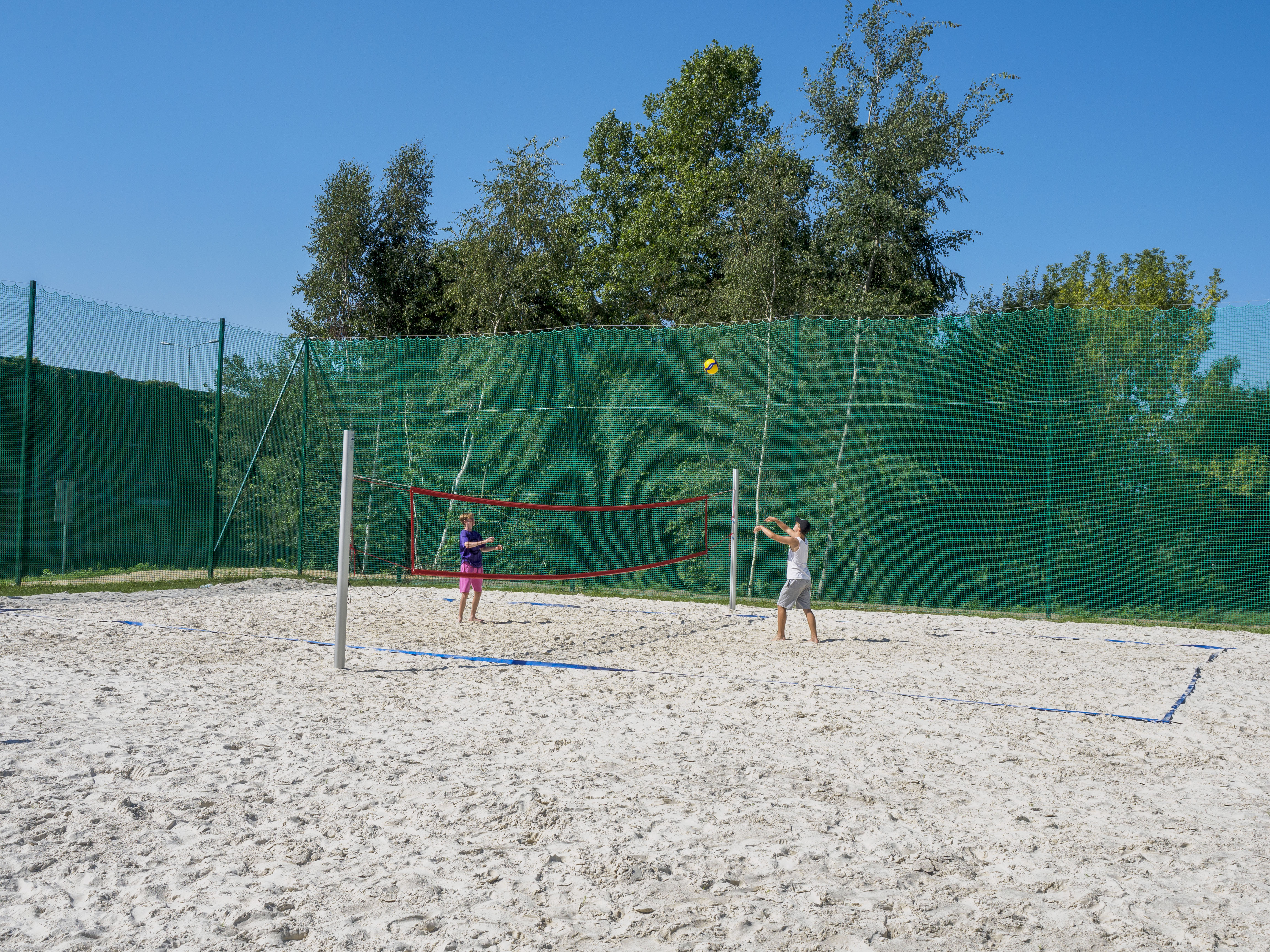 Chłopcy grający w siatkówkę plażową na nowym boisku