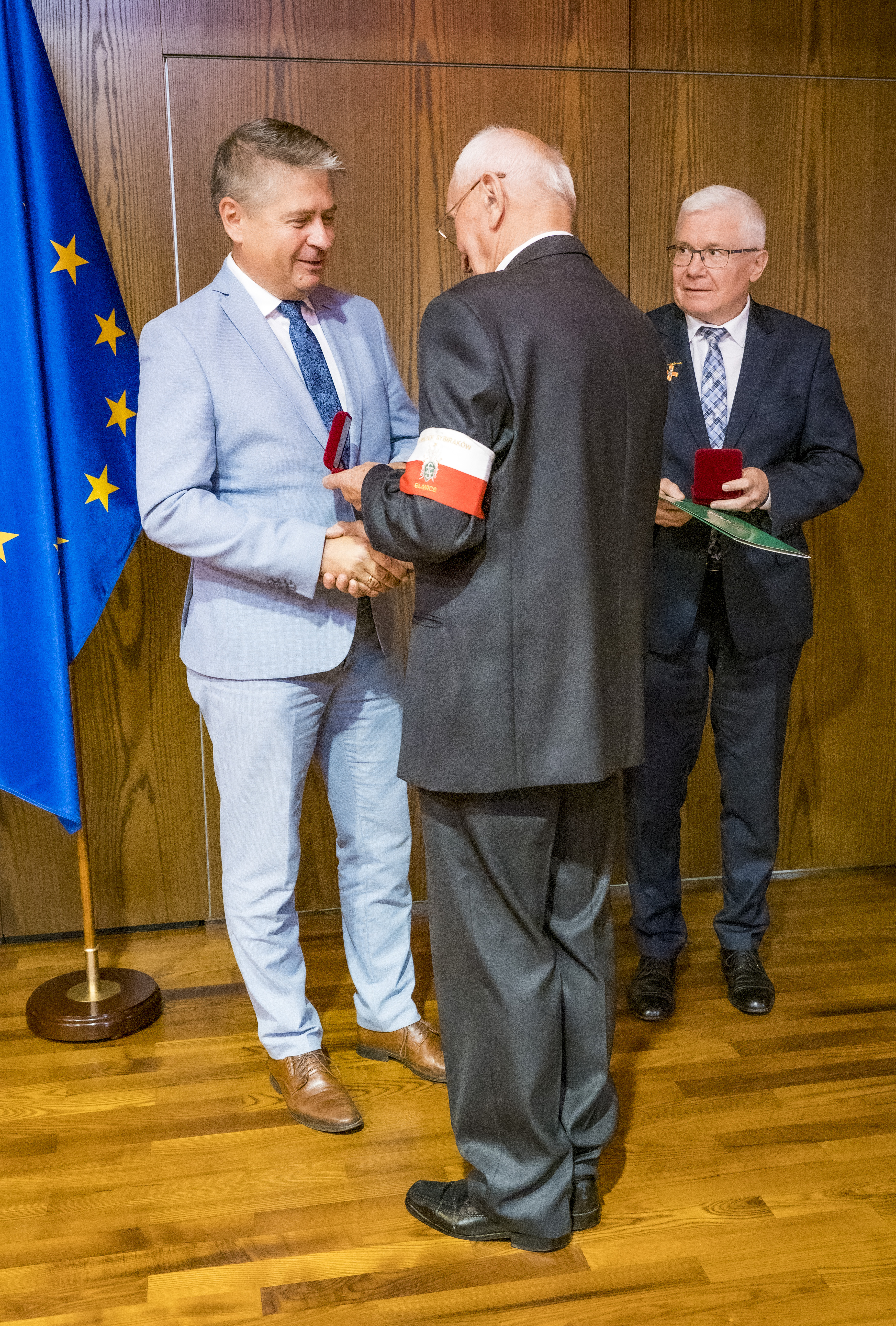Przewodniczący Rady miasta odbiera medal z rąk prezesa Związku sybiraków