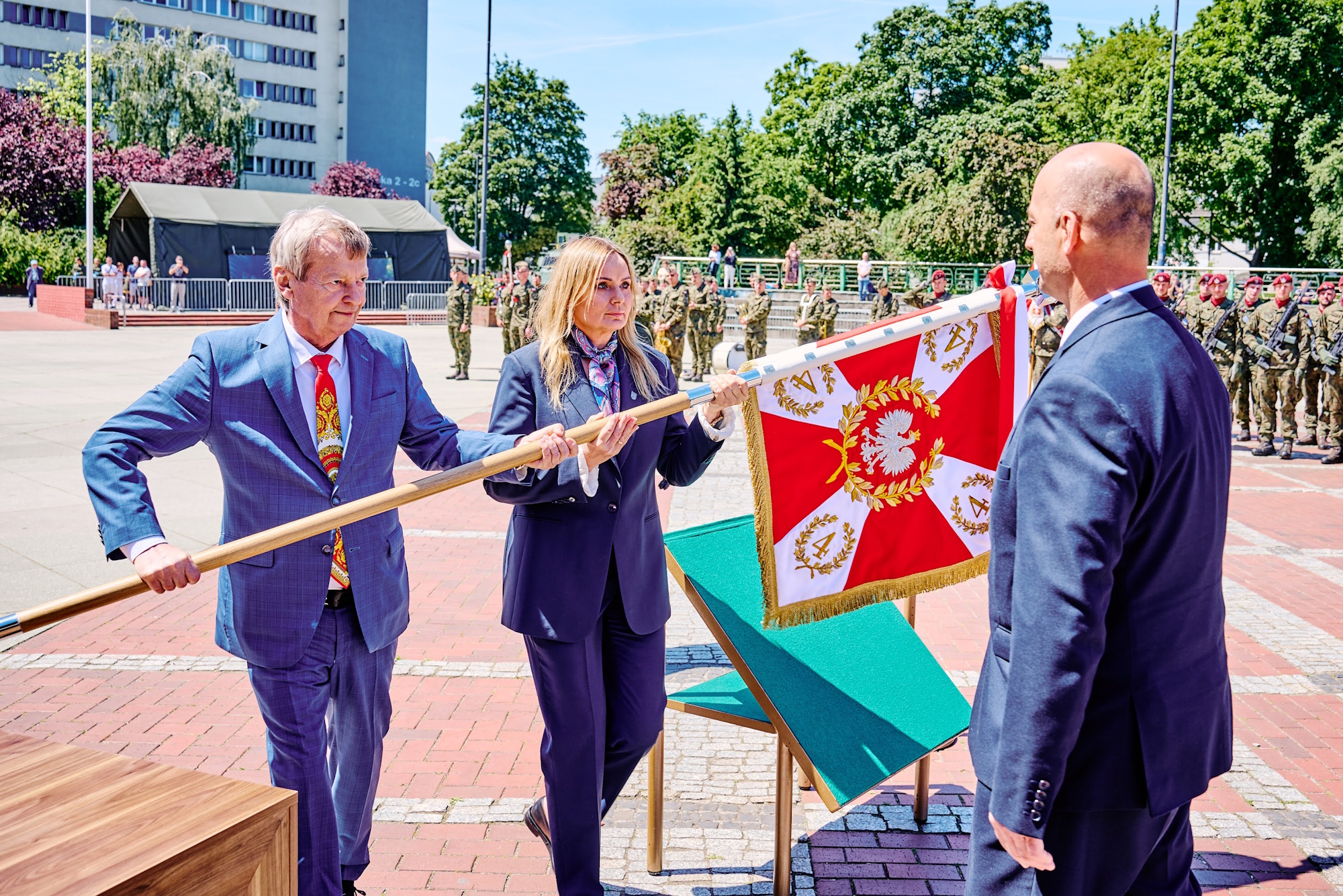 prezydent Glwiic i dwóch mężczyzn ze sztandarem