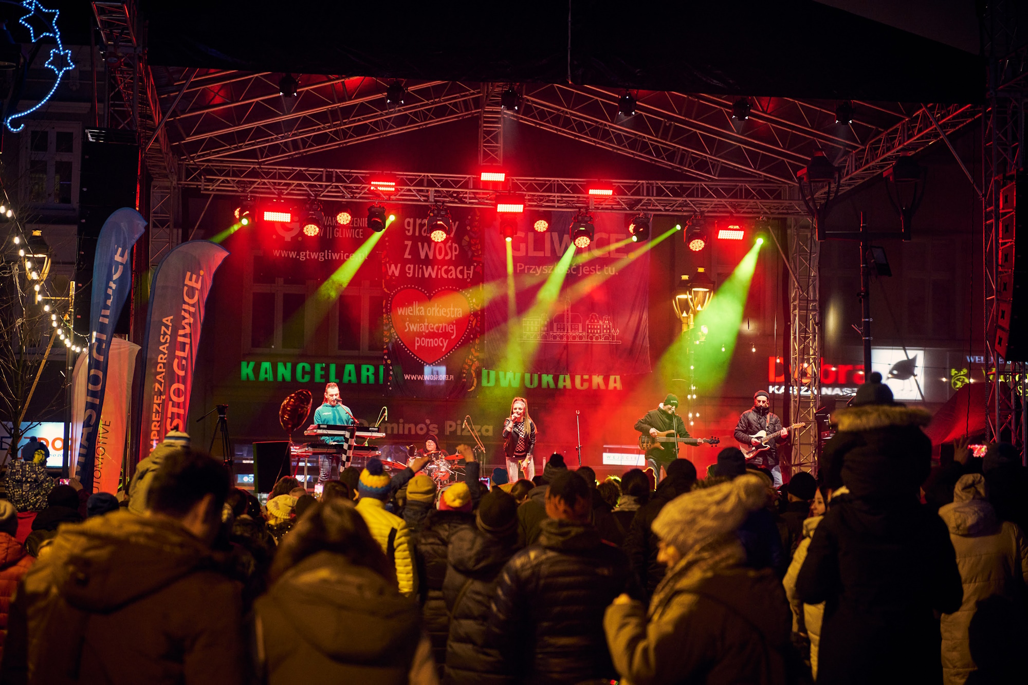 Ludzie stoją pod sceną, na scenie występuje zespół