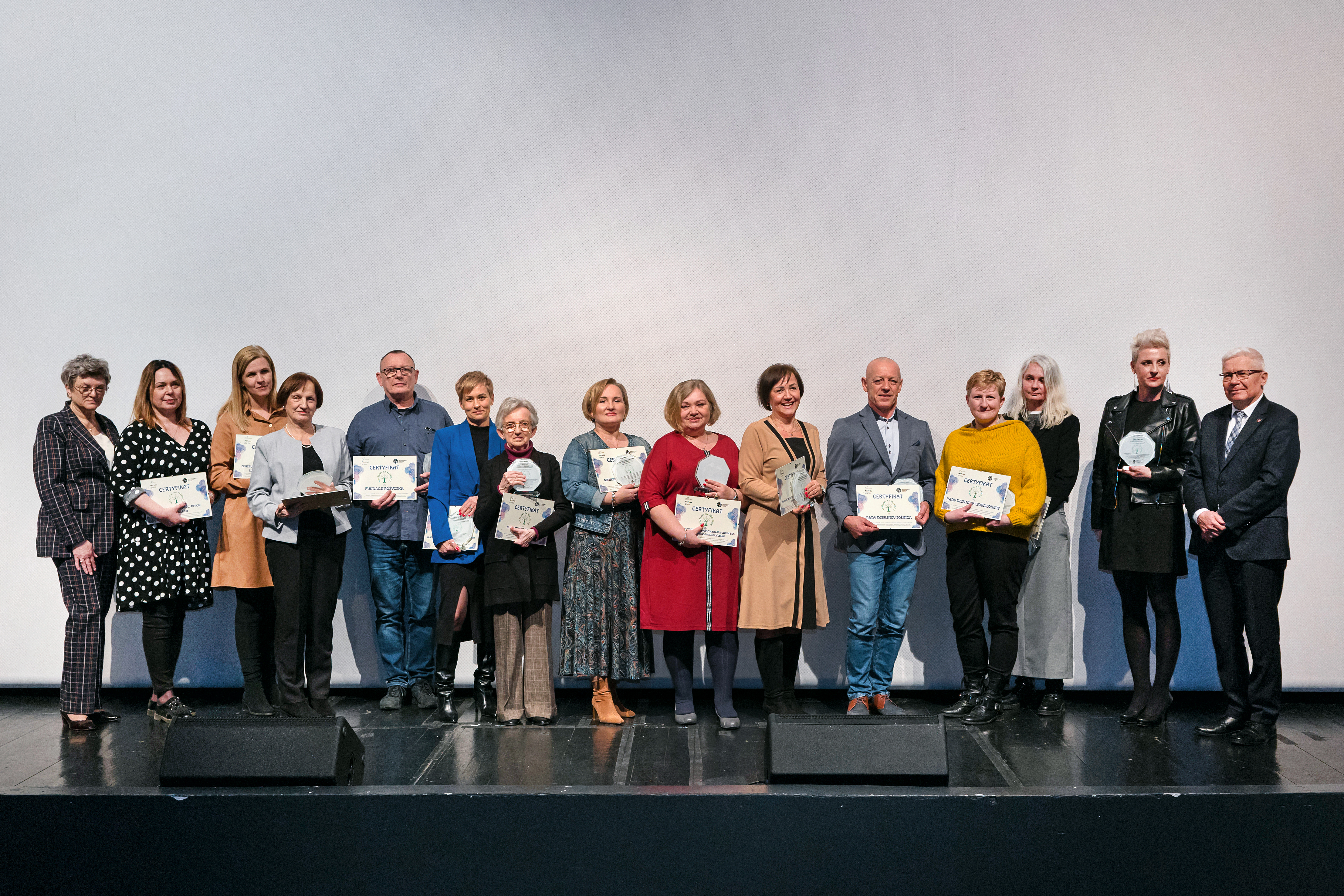 Osoby nagrodzone certyfikatem "Wrażliwi na przemoc" pozujący do zdjęcia z prezydentem Gliwic Adamem Neumannem