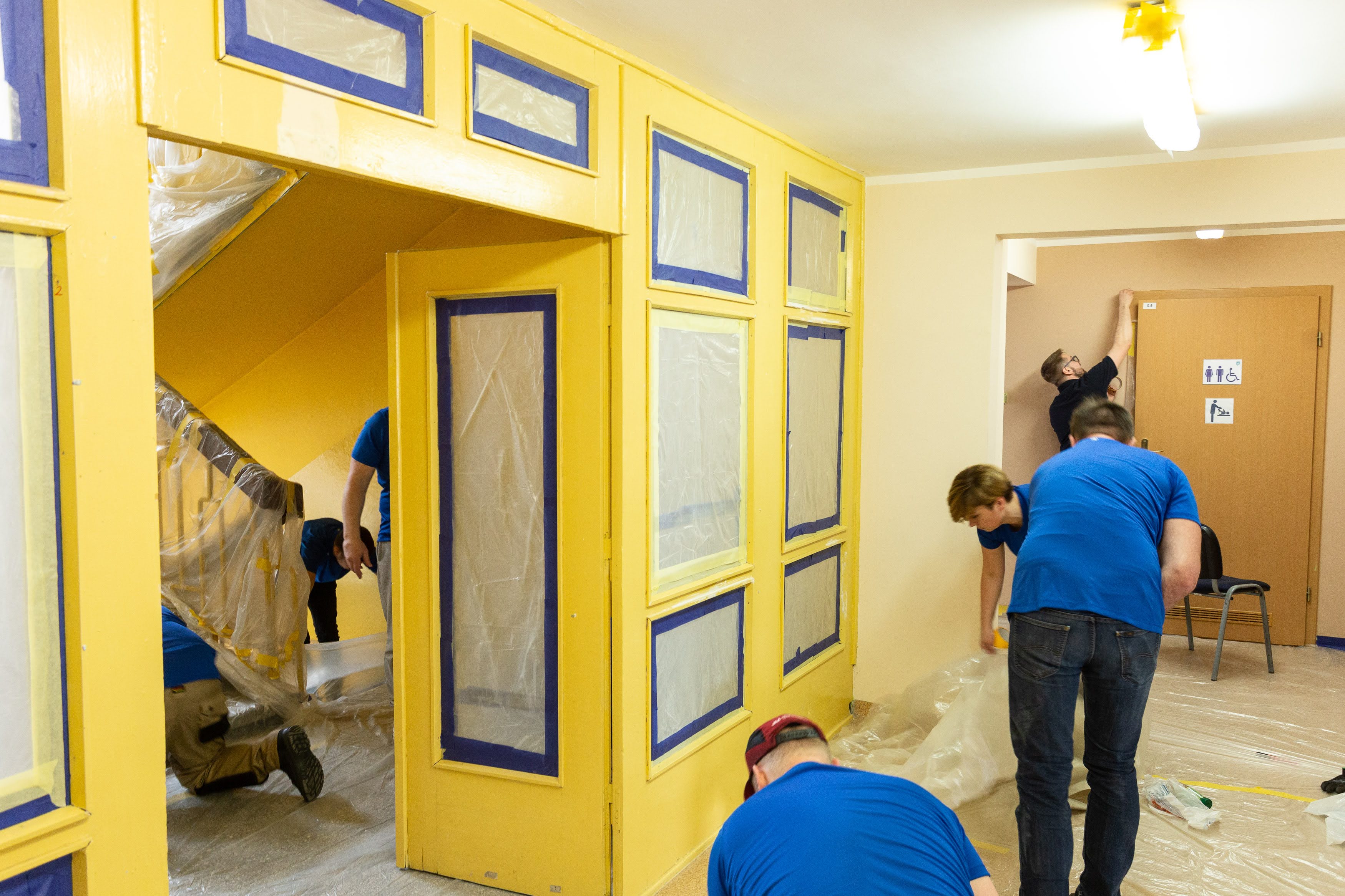 wolontariusze zabezpeiczają wnętrza przed malowaniem