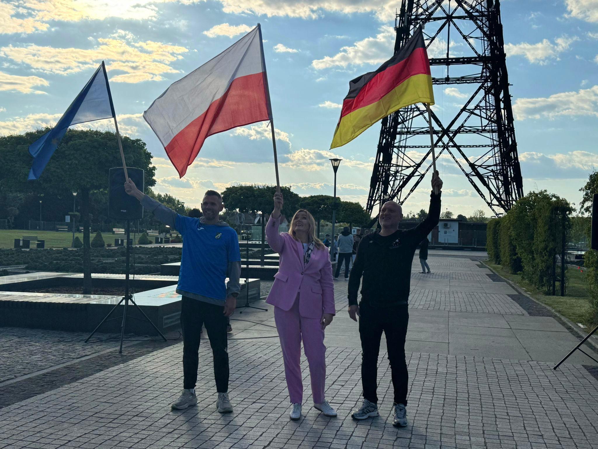 Fot. UM w Gliwicach Prezydent Gliwic i dwóch mężczyzn z flagami pod Radiostacją
