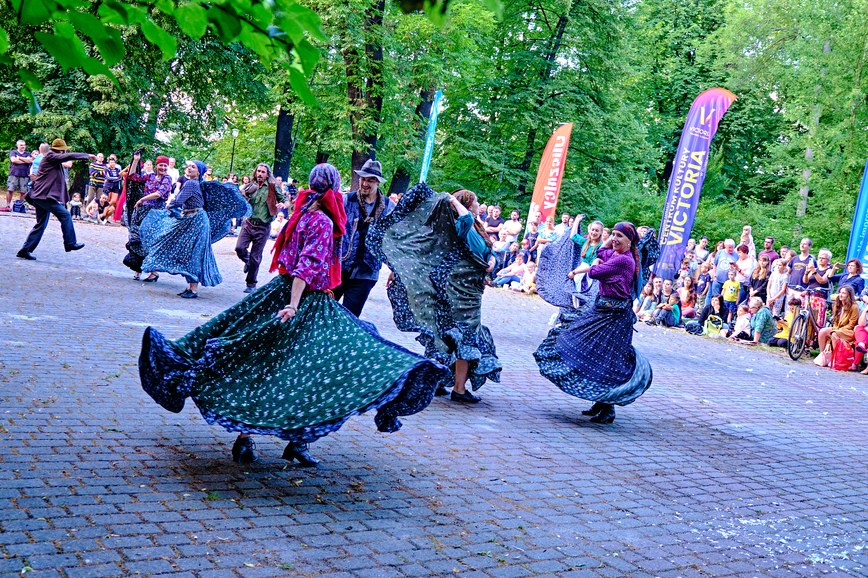 cygański taniec, grupa aktorów wiruje w parku