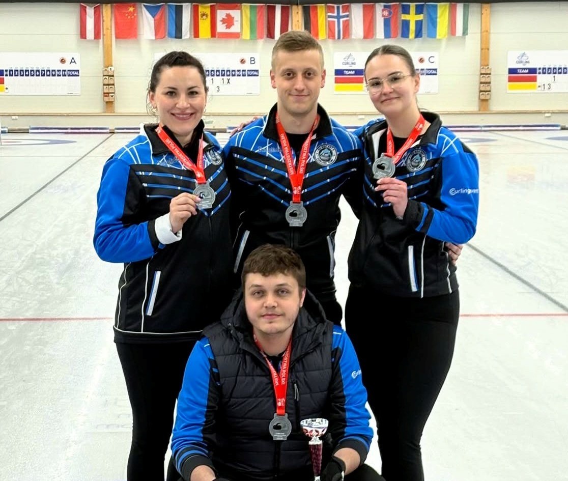 młodzi ludzie z medalami na lodzie