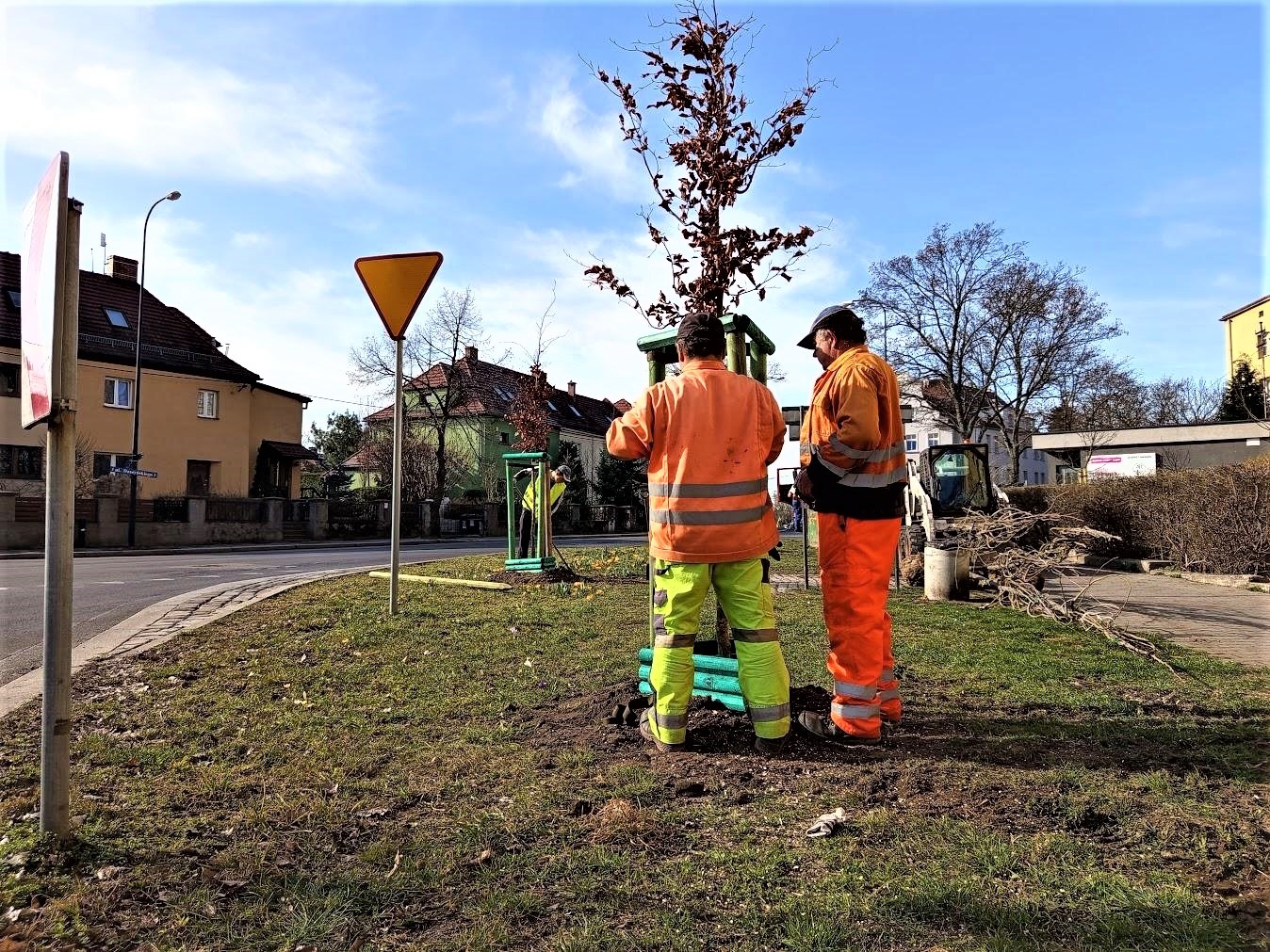 ludzie przy drzewie w zielonym i pomarańczowym kombinezonie