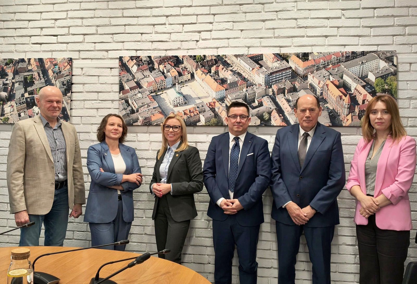 Trzech mężczyzn i trzy kobiety na tle ściany