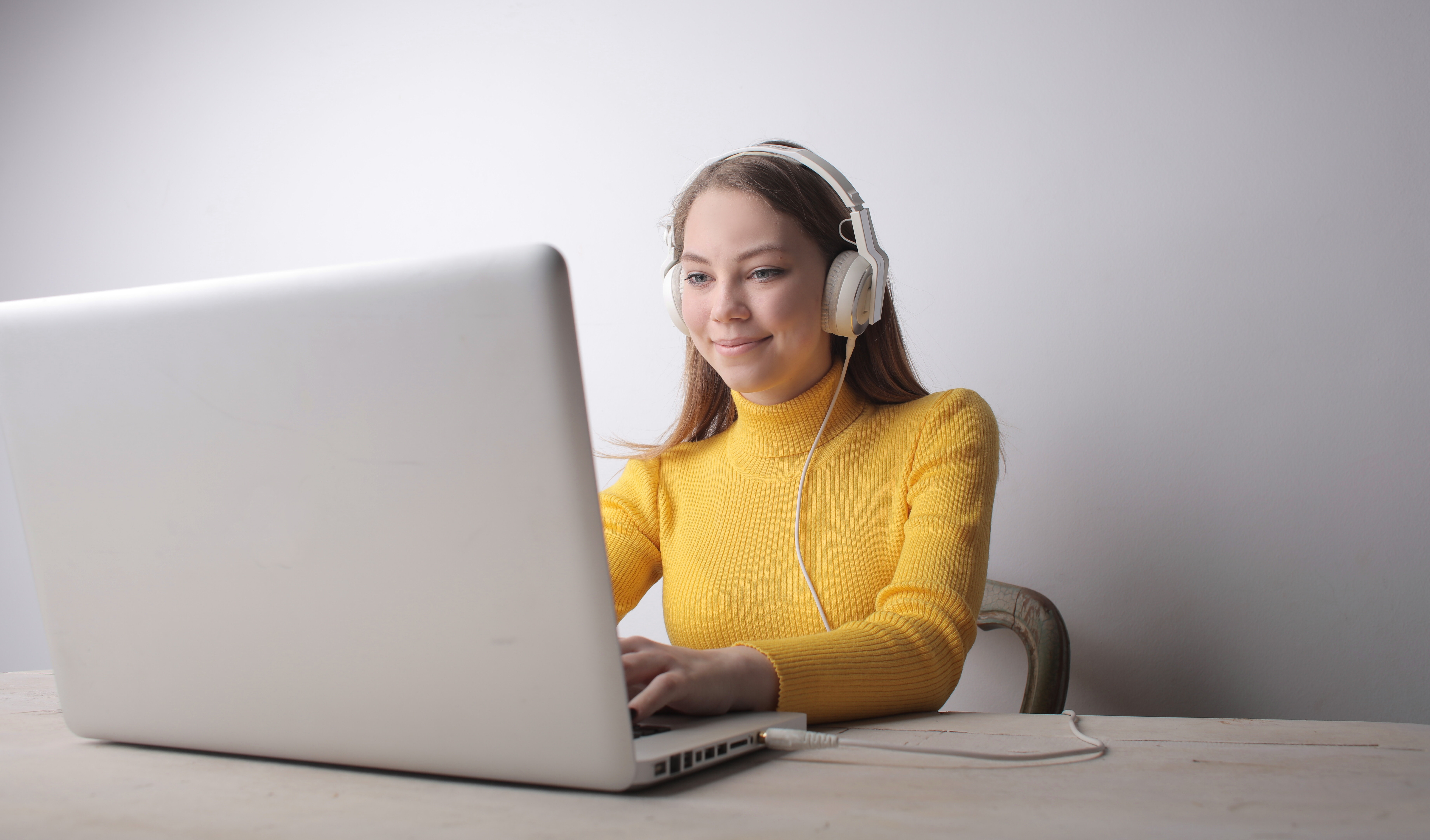 dziewczynka ze słuchawkami na uszach przed laptopem