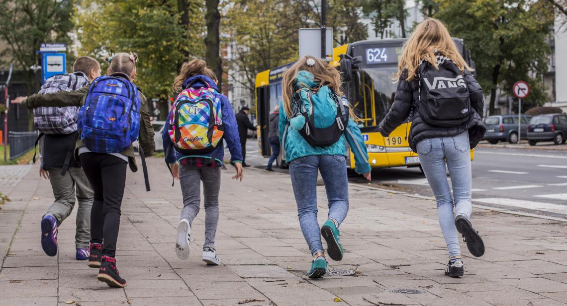 dzieci biegnące do autobusu